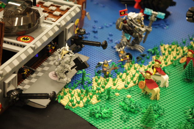 Ein Lego-Schlossmodell mit verschiedenen Lego-Teilen, einschließlich Spielzeugen, Pflanzen und anderen Gegenständen darauf.