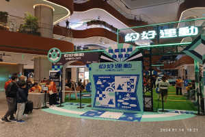 Gruppe von Teilnehmern auf der Hong Kong Sports Expo 2019 vor einem Schild stehend, mit einem Tisch und verschiedenen Gegenständen im Hintergrund.