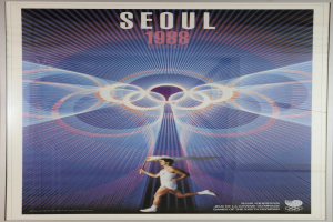 Eine Person, die mit den Olympischen Ringen im Hintergrund läuft und die Wörter "Olympische Spiele" quer darüber geschrieben hat, auf einem Plakat für die Olympischen Spiele 1988 in Seoul, Südkorea.
