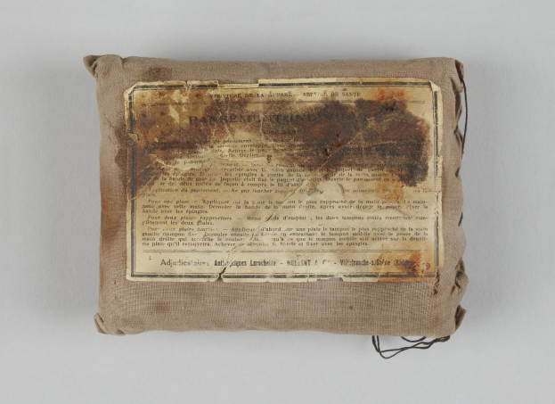 Kleiner Verbandkastenbeutel mit einem informativen Blatt Papier oben drauf.