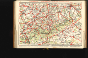 Offenes Buch mit detaillierter Karte von Deutschlands Straßen und Autobahnen auf schwarzem Hintergrund.