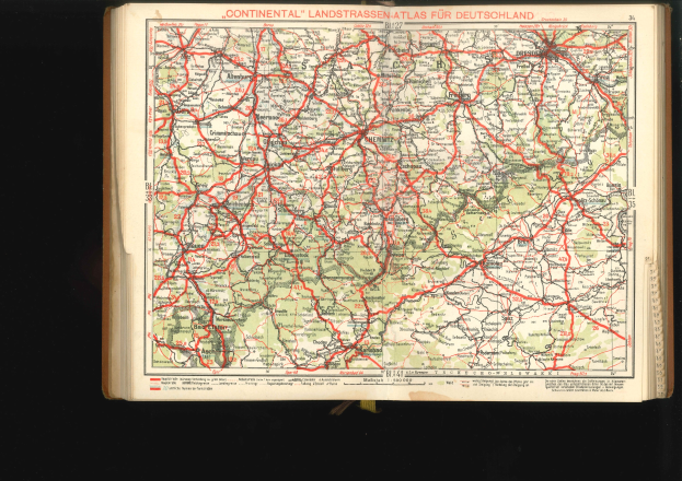 Offenes Buch mit detaillierter Karte von Deutschlands Straßen und Autobahnen auf schwarzem Hintergrund.