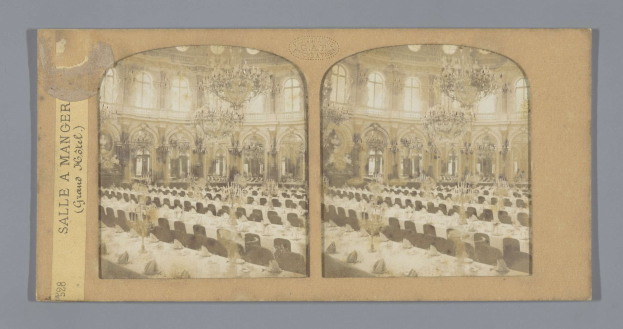 Altes Schwarz-Weiß-Foto eines prunkvollen Hotel-Speisesaals mit langen Tischen, üppigen Kronleuchtern, hohen Fenstern und einem linken Schild mit der Aufschrift "Sale a Manger, Grand Hotel".