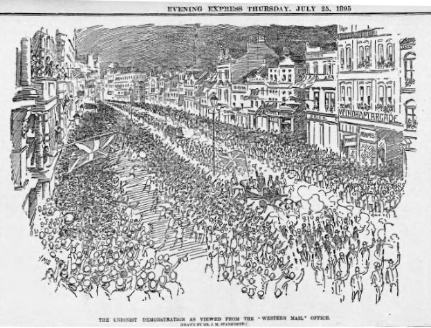 Schwarze und weiße Zeichnung einer Menge, die zwischen Gebäuden eine Straße entlanggeht, mit Text oben und unten: "Die Unionistendemonstration, wie sie vom Western Mail Office aus gesehen wird."