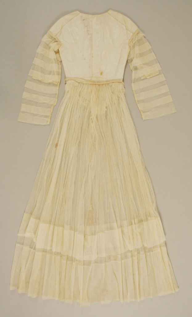 Ein weißes, langärmeliges Kleid mit einer gerafften, bodenlangen Schleppe auf einer weißen Oberfläche, das eine hohe Taille, voluminösen Stoff und einen dezenten Glanz aufweist.