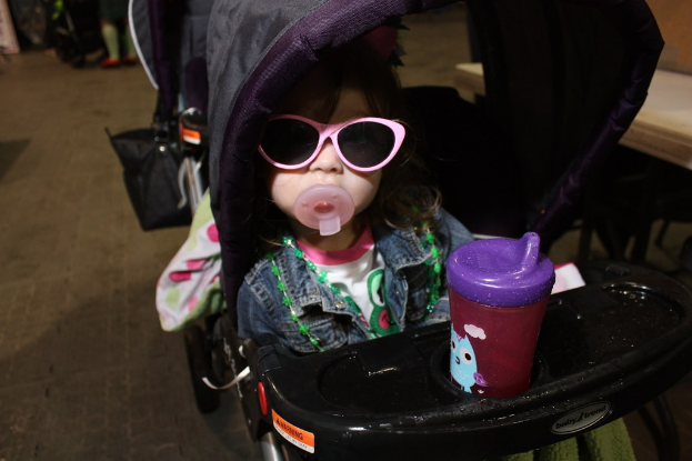 Ein Kind sitzt in einem Walker auf der Straße.