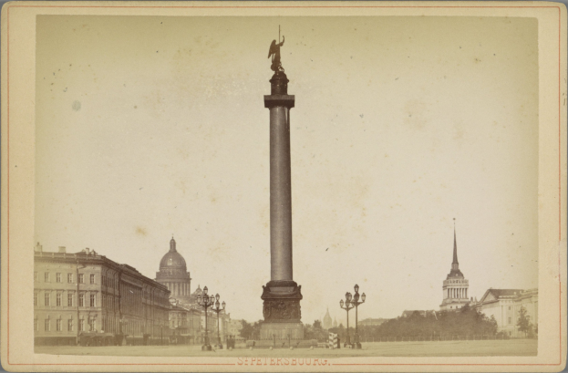 Altes Schwarz-Weiß-Foto eines Denkmals in einem städtischen Platz, umgeben von Gebäuden, Straßenlaternen, Lichtern, Bäumen und einem klaren Himmel; Text erscheint am unteren Rand.