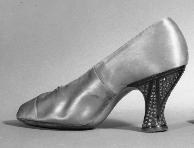Schwarz-weiß-Foto eines Paares glänzender, hochhackiger Damenschuhe aus den 1930er Jahren.