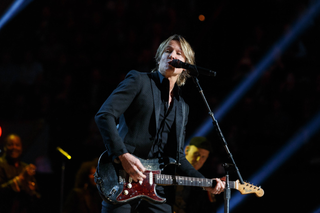 Keith Urban performs auf der Bühne im Joint im Hard Rock Hotel & Casino in Las Vegas, spielt Gitarre mit einem Mikrofon vor sich und Musikern im Hintergrund bei gedämpftem Licht.