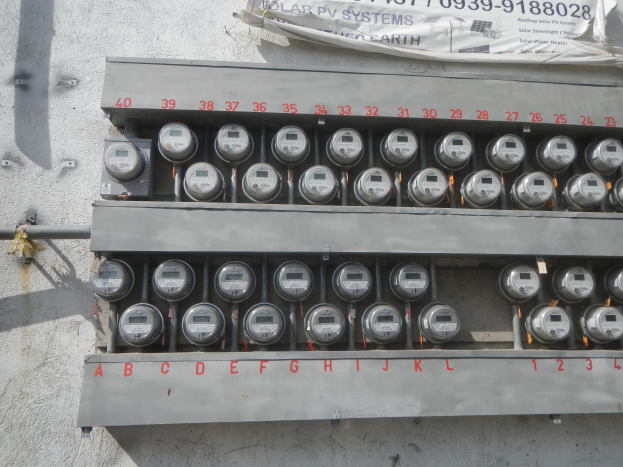 Nahaufnahme eines Stromzählers an der Seite eines Gebäudes mit einem Banner oben