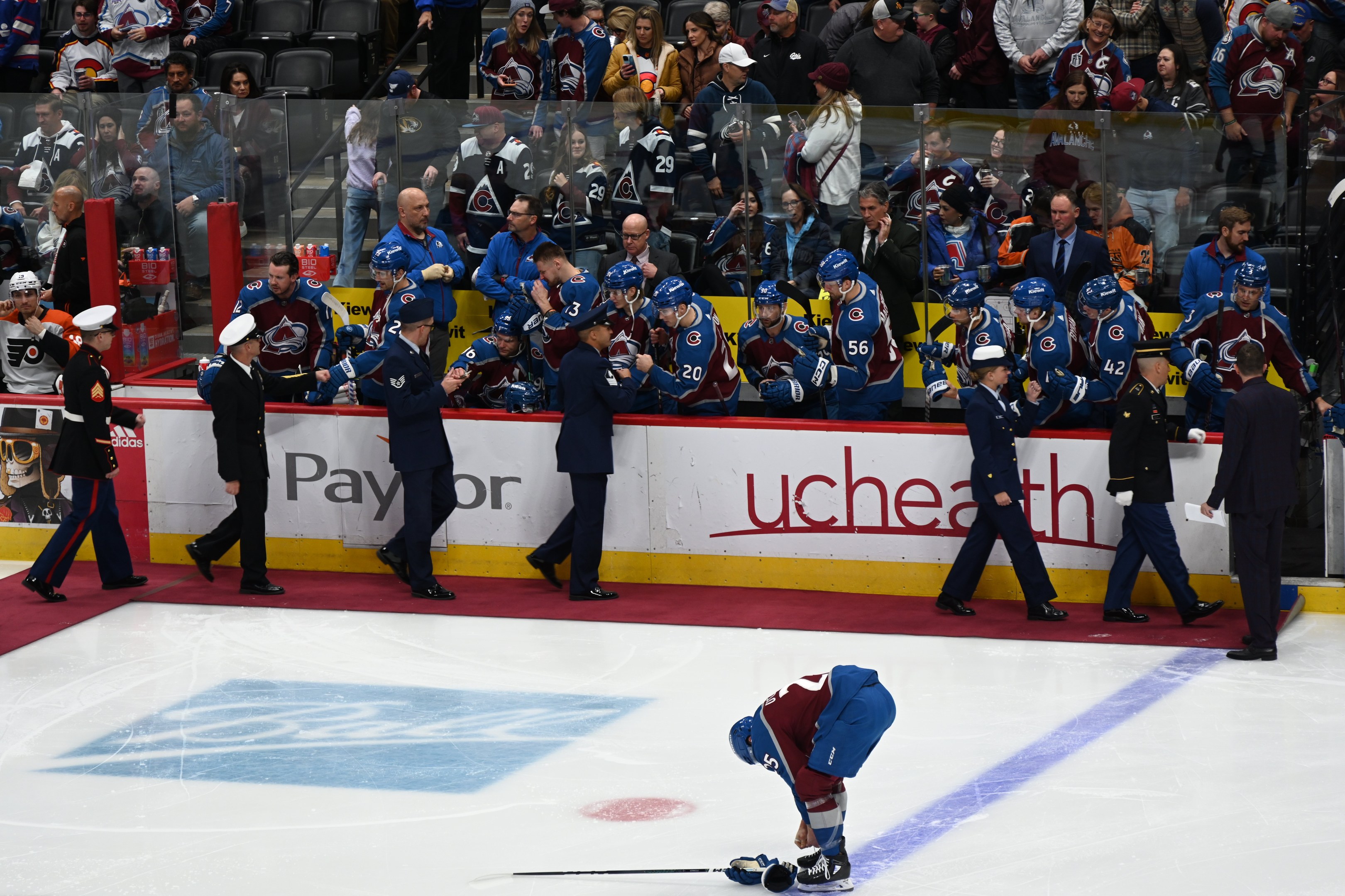 Ein Eishockeyspieler auf dem Eis umgeben von Fans und Teammitgliedern während eines NHL-Spiels zwischen Colorado Avalanche und San Jose Sharks am 24. März 2015.